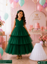 Young girl in a green dress with balloons and a 'little princess' sign in the background
