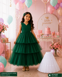 Young girl in a green dress with balloons and a 'little princess' sign in the background