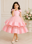 Young girl in a pink dress standing in a room with floral decorations.