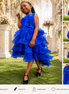 Young girl in a blue dress standing outdoors with floral decorations.