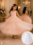 Young girl in a pink dress twirling in a grand room with chandeliers and floral arrangements.