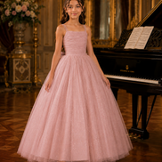 Young girl in a pink dress standing in a formal setting with a grand piano.