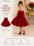 Young girl wearing a red flower dress in a elegant interior setting.