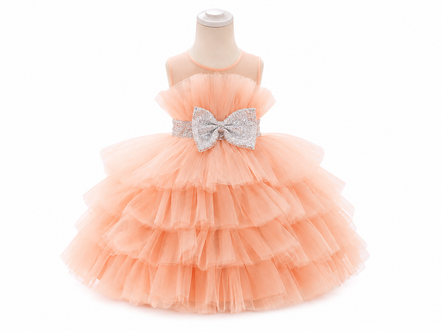 Peach-colored tiered dress with a large bow on a mannequin against a white background