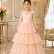 Young girl in a peach lace dress standing in an elegant room with chandelier and floral arrangement.